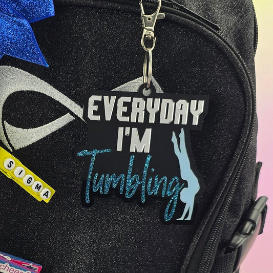 Black backpack with various items attached on a gradient background