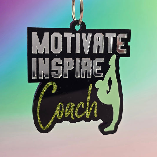Keychain with motivational text 'Motivate Inspire Coach' on a colorful gradient background